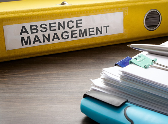 yellow binder labeled absence management with stacked papers and office supplies on wooden surface illustrating absence management strategies and documentation