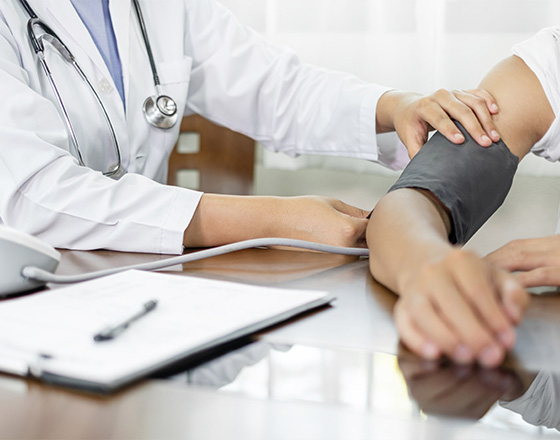 doctor measuring blood pressure on patient arm with medical equipment