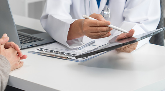 doctor consulting with patient using digital tablet and laptop discussing health options with focus on seven key points