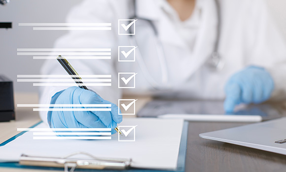 medical professional checking off tasks on a checklist with a pen and tablet three tasks completed