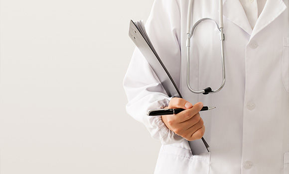 doctor holding clipboard and pen with stethoscope visible wearing white coat for medical consultation